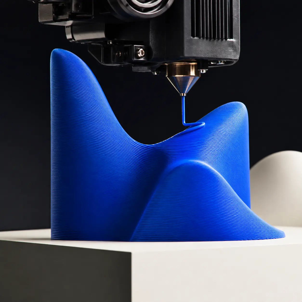 Close-up of a 3D printer creating an abstract blue Axis Studios form